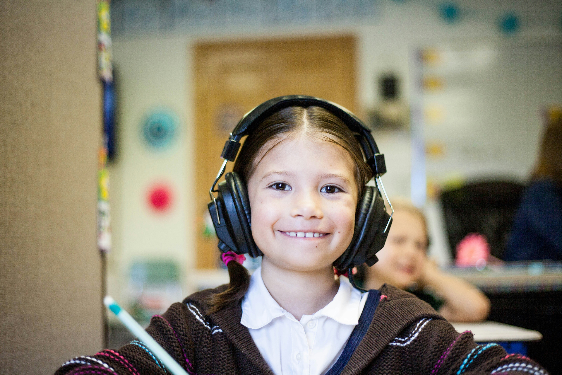 Young piano student smiling with headphones during a private piano lesson at Leaside Music School in Leaside, Toronto