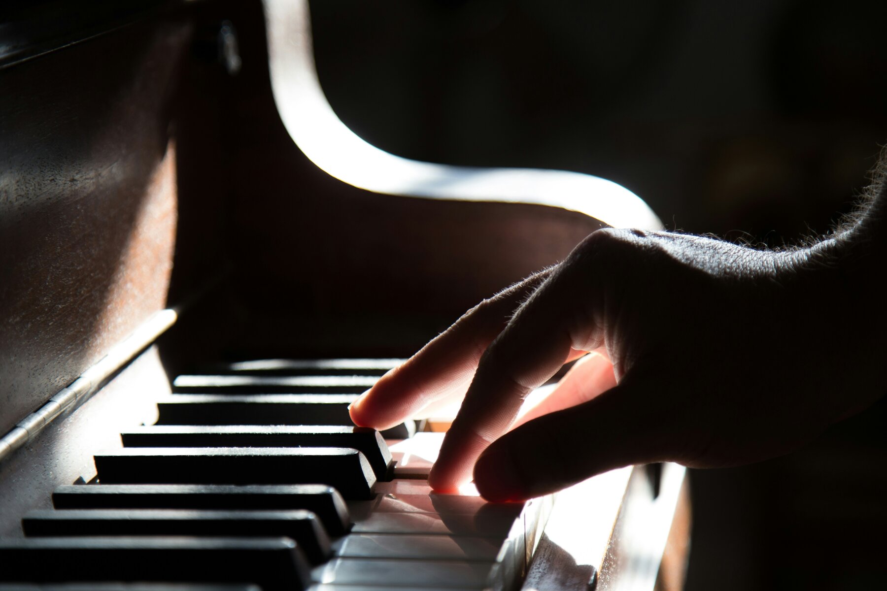Close-up of a student's hand playing piano keys during a lesson